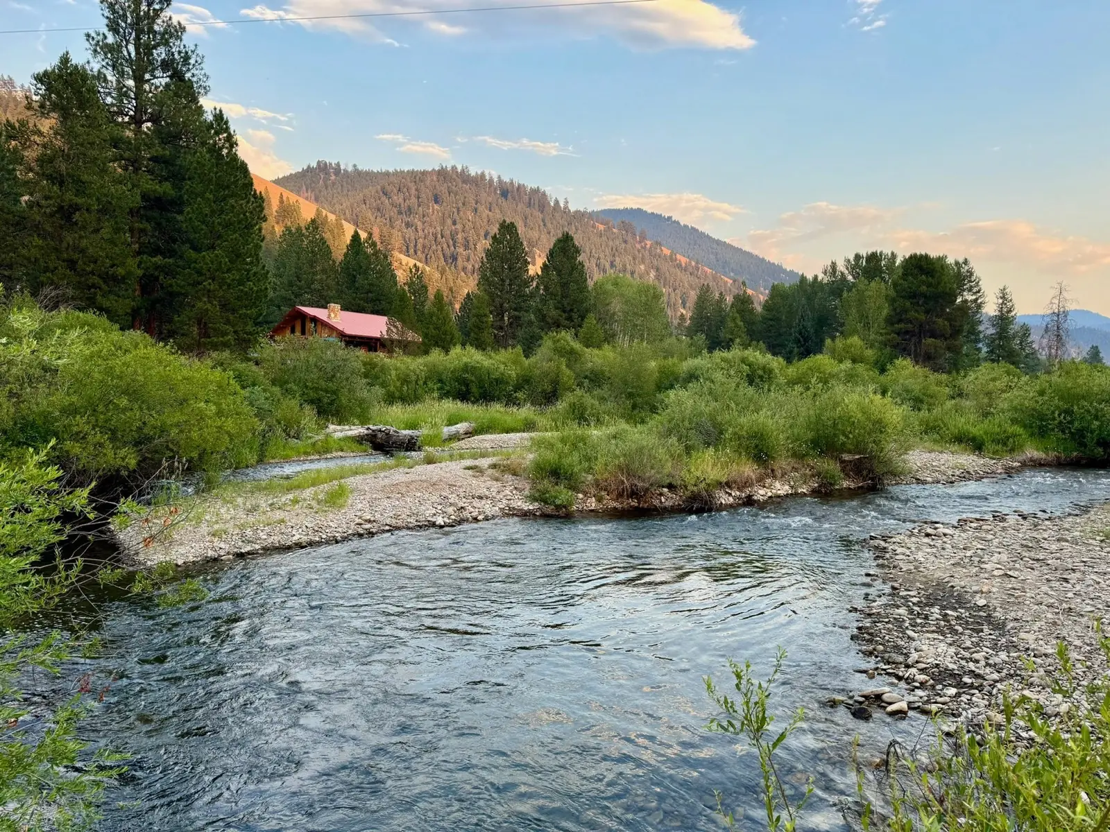 The West Fork below a red-roofed building, with mountains beyond