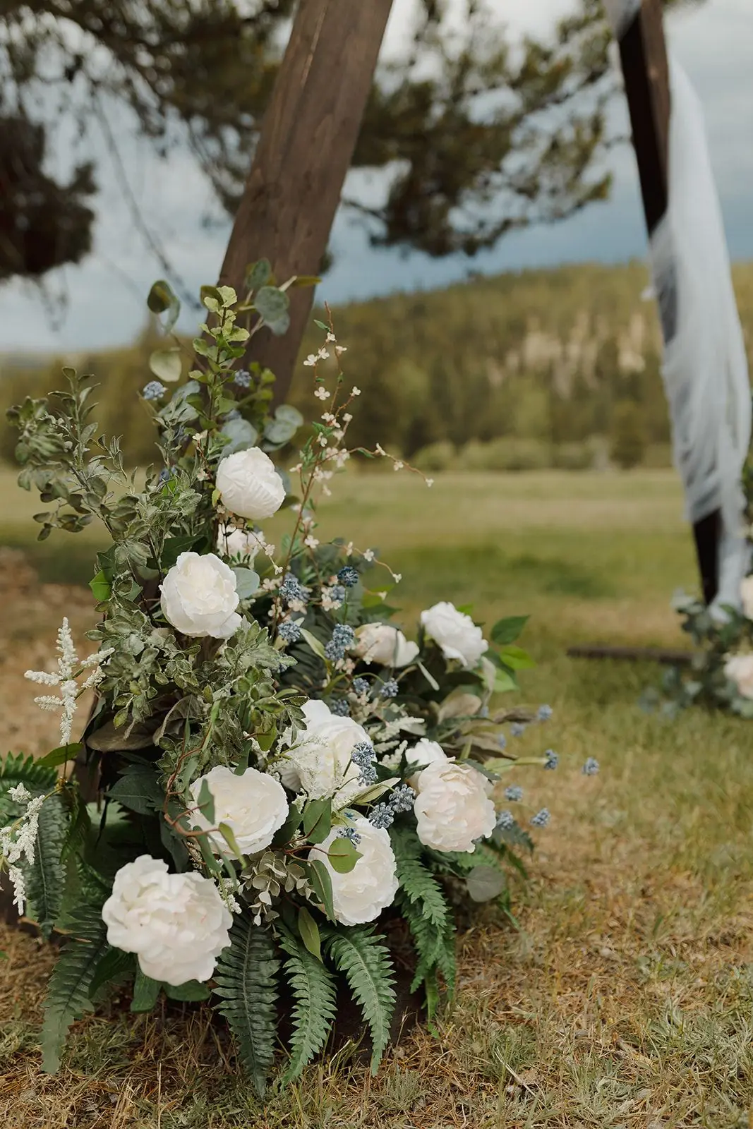 White and green florals on the ceremony arch