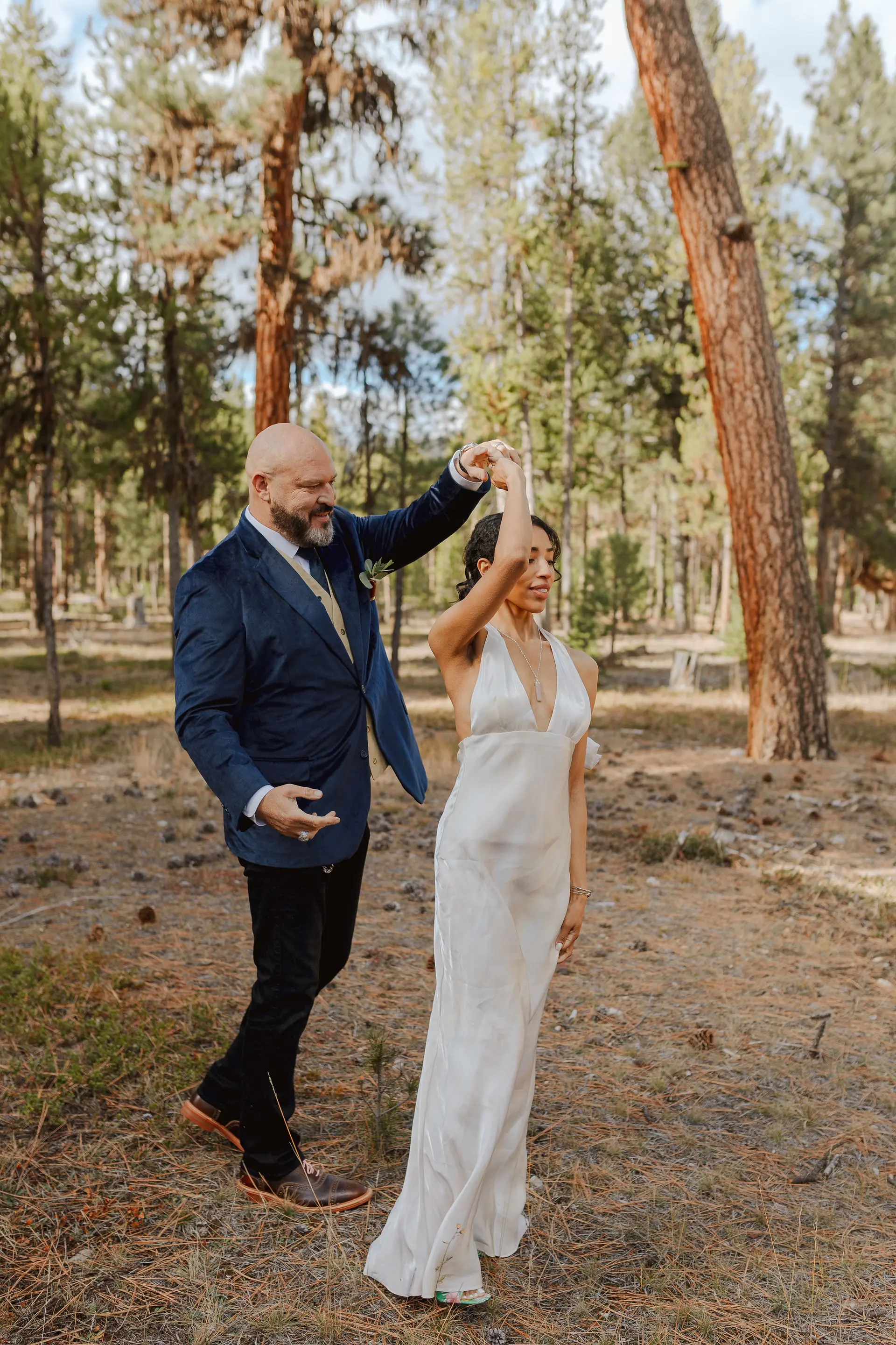 A couple dancing among the tall ponderosa pines at Alta Ranch