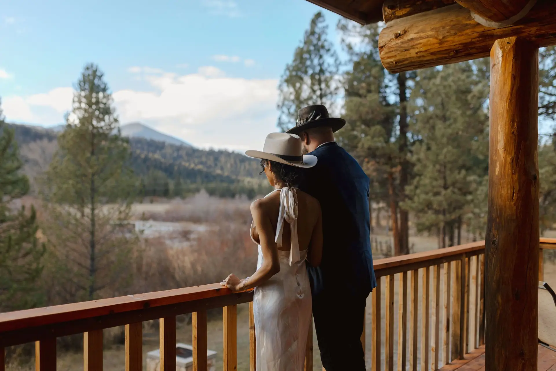 A couple on a cabin deck looking out over the valley