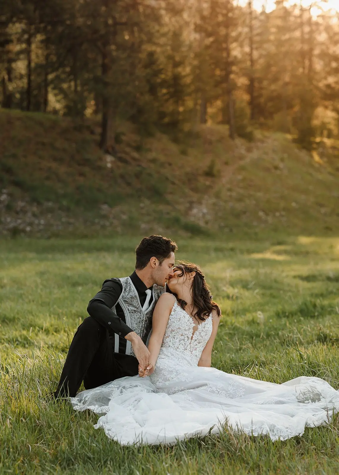 A couple kissing in the grass at golden hour